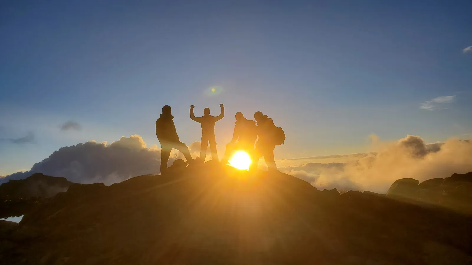 Hikers silhouetted at sunrise on a Kenyan summit