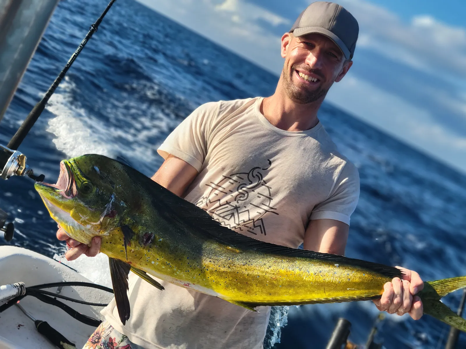 Angler holding a freshly caught mahi-mahi on a deep-sea boat